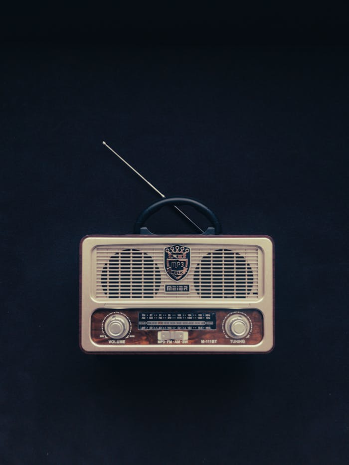 gallery-5 Classic vintage radio with knobs and antenna against a black background, showcasing retro technology.