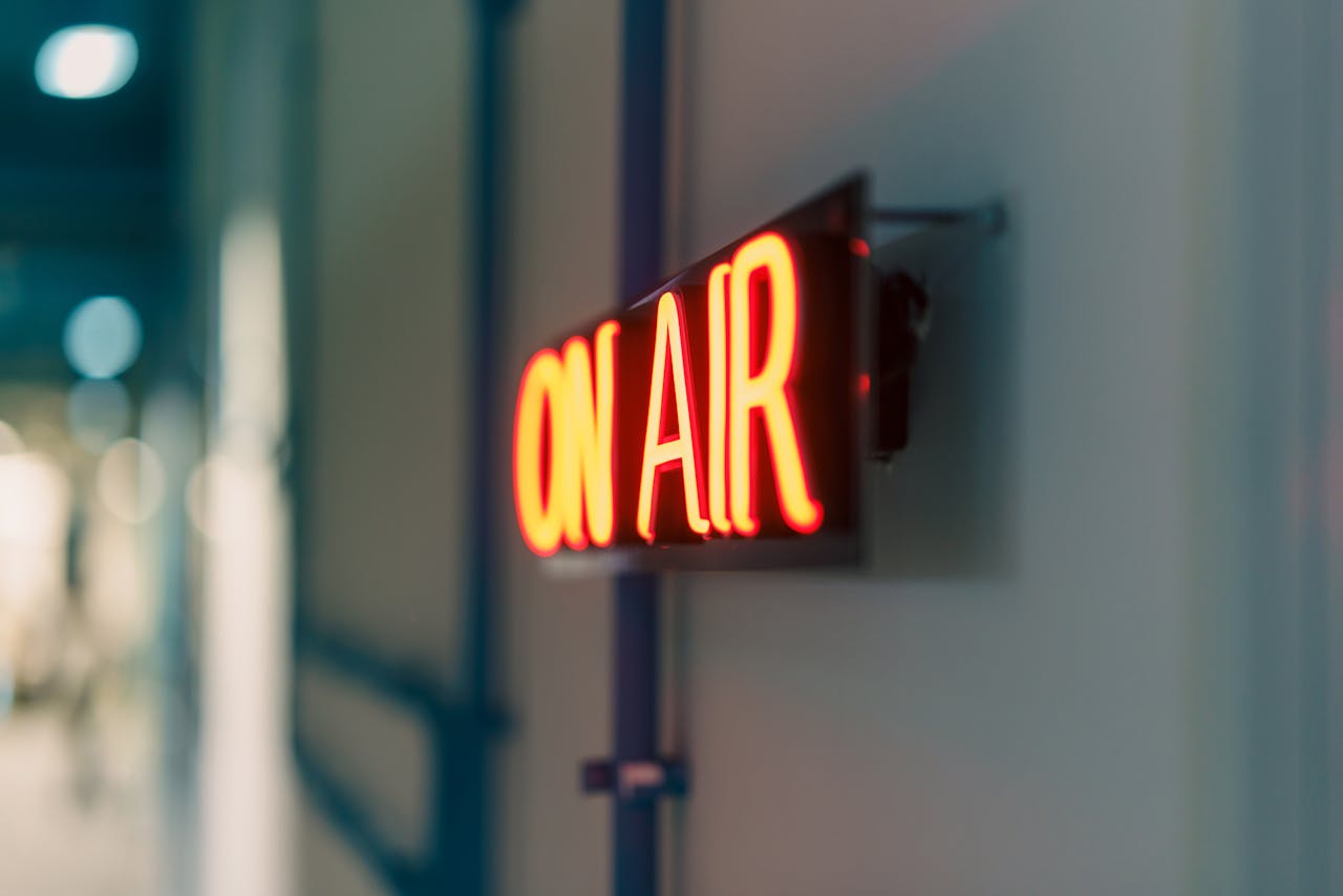 gallery-2 Bright red 'On Air' neon sign captured indoors, ideal for media content.