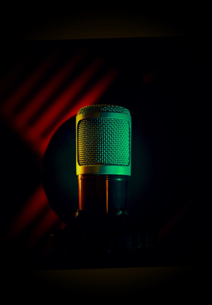 Artistic shot of a condenser microphone with colored lighting, ideal for audio and music themes.