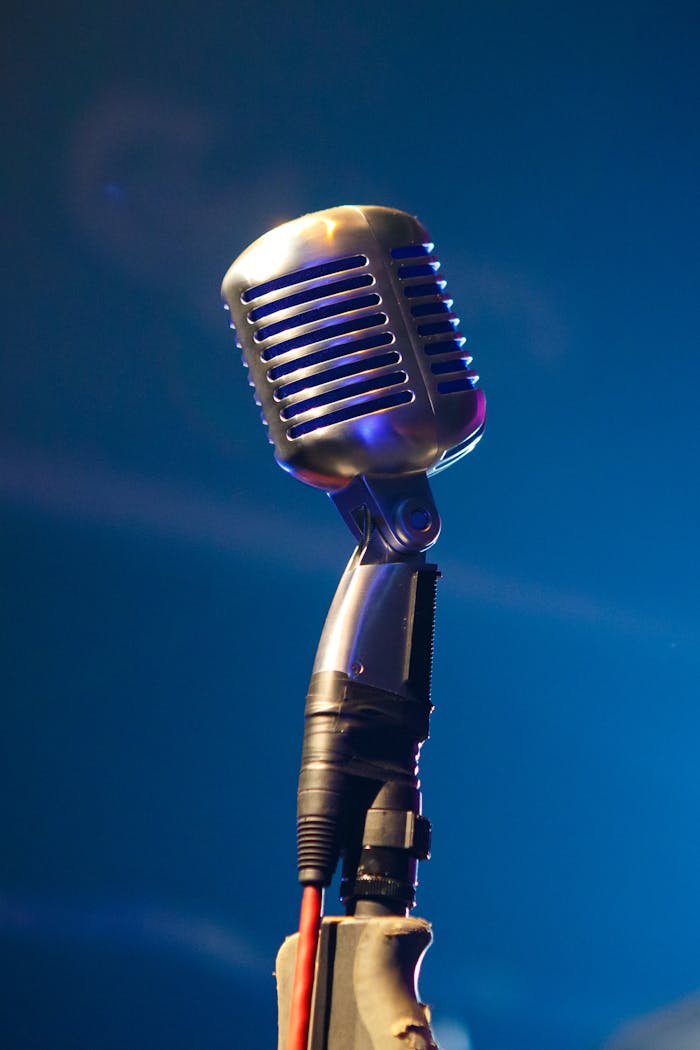 services-01 Retro microphone on stage with blue lighting creates a nostalgic musical vibe.