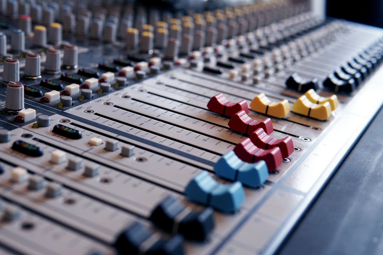 gallery-6 Detailed close-up of a professional audio mixing console with colorful sliders.