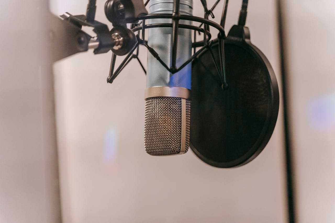 about-img Close-up of a condenser microphone with pop filter in a studio setting, ideal for audio and podcasting.